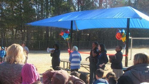 Gwinnett County education officials gather Thursday, Nov. 21 at Lilburn Elementary for a ribbon-cutting ceremony of the school's new sun shade structure. COURTESY OF GWINNETT COUNTY PUBLIC SCHOOLS
