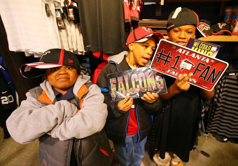 Corde Astro, 7, (from left) Quinntavious Harkness, 8, and Khalic English, 9, from the Atlanta Action Ministries, check out the Falcons items while cruising the store with rookie lineman Jake Matthews on a Christmas shopping spree at Dick's Sporting Goods on Tuesday, Dec. 16, 2014, in Duluth. CURTIS COMPTON / CCOMPTON@AJC.COM