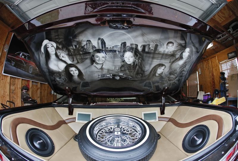 Inside the trunk is a mural of Alfredo “Freddy” Quintero’s family. Bob Andres/robert.andres@ajc.com