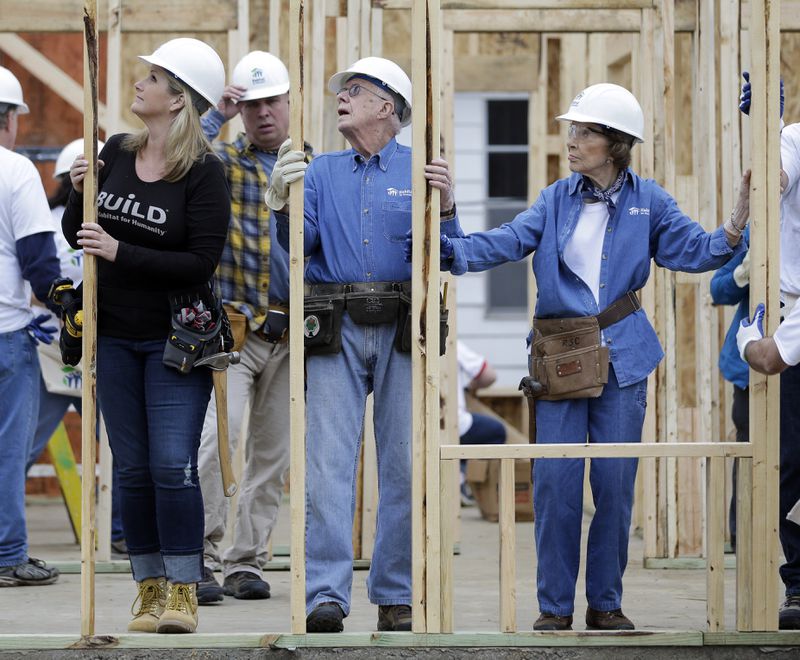 Former President Jimmy Carter works between his wife, Rosalynn Carter, right, and singer Trisha Yearwood, left, at a Habitat for Humanity building site Monday, Nov. 2, 2015, in Memphis, Tenn. Behind Yearwood is her husband, singer Garth Brooks. Carter and his wife, Rosalynn, have volunteered a week of their time annually to Habitat for Humanity since 1984, events dubbed "Carter work projects" that draw thousands of volunteers and take months of planning. (AP Photo/Mark Humphrey)