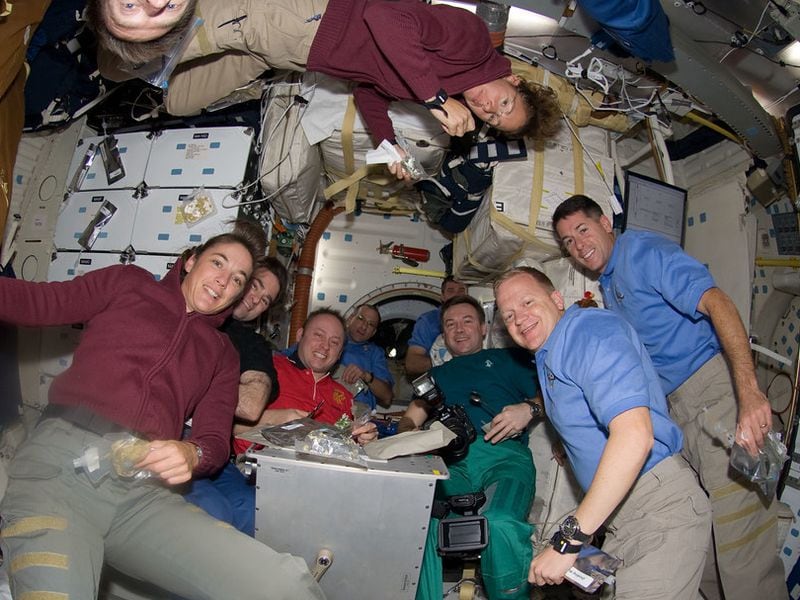 NASA Astronauts Eric Boe (second from right) and Shane Kimbrough (right) enjoy a Thanksgiving meal with other crew members aboard the space shuttle Endeavor in 2008.
