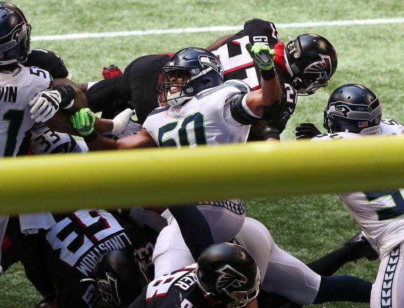 Falcons running back Todd Gurley goes over the top of Seattle Seahawks defenders into the end zone for a touchdown during the second quarter of the season opener Sunday, Sept. 13, 2020, in Atlanta.   (Curtis Compton / Curtis.Compton@ajc.com)