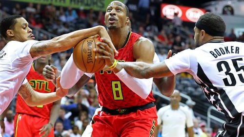 Hawks center Dwight Howard draws a foul on a rebound during a double team by Brooklyn Nets K.J. McDaniels (left) and Trevor Booker in a NBA basketball game on Sunday, March 26, 2017, in Atlanta. Curtis Compton/ccompton@ajc.com