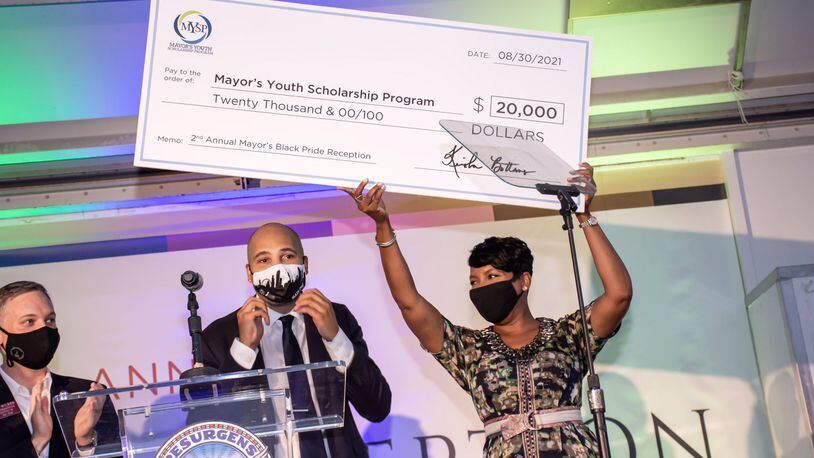 Atlanta Mayor Keisha Lance Bottoms raises a check in celebration of the more than $30,000 raised at her reception for the kick off of Black Pride weekend. CONTRIBUTED