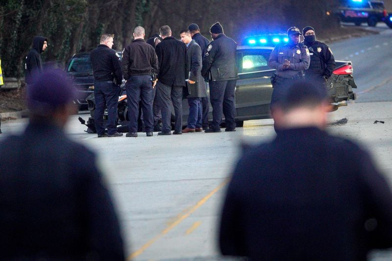 Atlanta police officers and Fulton County deputies gathered at the scene of the fatal shooting on Bolton Road. 