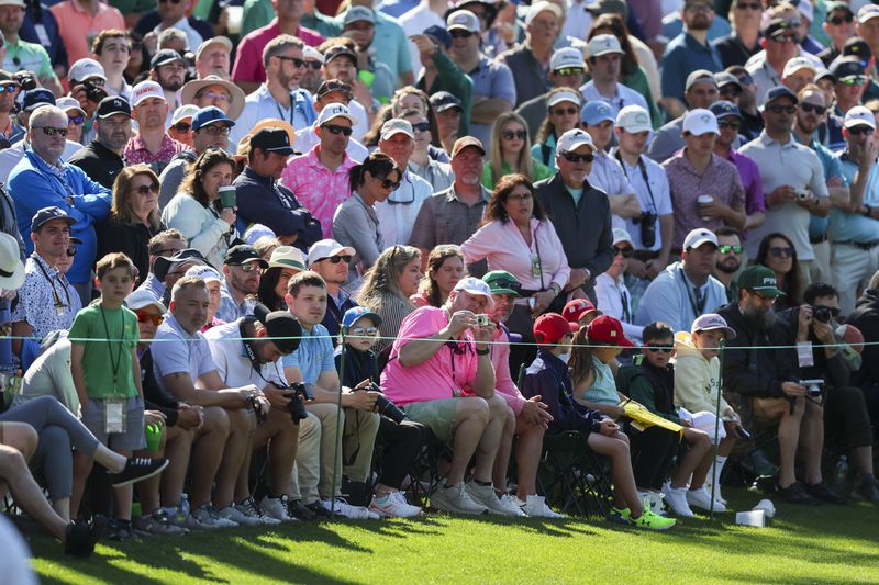 Patrons watch Tiger Woods practice on the 16th green during the practice round of the 2024 Masters Tournament at Augusta National Golf Club, Monday, April 8, 2024, in Augusta, Ga. (Jason Getz / jason.getz@ajc.com)