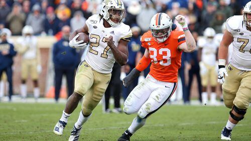 Jordan Mason #27 of the Georgia Tech Yellow Jackets rushes past Zane Zandier #33 of the Virginia Cavaliers in the second half during a game at Scott Stadium on November 9, 2019 in Charlottesville, Virginia. (Photo by Ryan M. Kelly/Getty Images)
