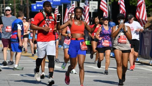 Runners make their way to cross the finish line  during the second day of 2021 Atlanta Journal-Constitution Peachtree Road Race on Sunday, July 4, 2021. (Hyosub Shin / Hyosub.Shin@ajc.com)