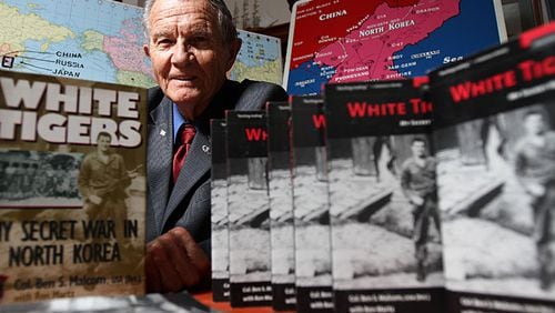 Col. Ben Malcom led guerilla fighters operating behind enemy lines in the North Korean War as a forerunner to what is known today as the U.S. Army Special Forces. Here, he is pictured with a book he wrote about his experiences. He stayed in the Army, serving in Vietnam and later commanding Fort McPherson in metro Atlanta,