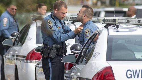 10/23/2018 — Peachtree Corners, Georgia — A Gwinnett County police officer makes sure his colleague’s uniform is in good order before they enter the Crowell Brothers Funeral Home for the visitation of slain Gwinnett County police officer Antwan Toney in Peachtree Corners. Officer Toney was allegedly shot and killed by 18-year-old Tafahree Maynard on Saturday. A three day man hunt ensued. Tafahree Maynard was located by authorities on Monday and was shot and killed after not complying with commands. (ALYSSA POINTER/ALYSSA.POINTER@AJC.COM)