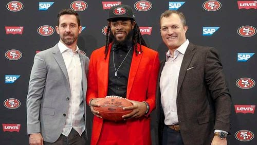 San Francisco 49ers head coach Kyle Shanahan, left, cornerback Richard Sherman, center, and general manager John Lynch, right, pose for a photo before an NFL football news conference in Santa Clara, Calif., Tuesday, March 20, 2018. Sherman agreed to a three-year deal with the 49ers. (AP Photo/Tony Avelar) ORG XMIT: CATA101