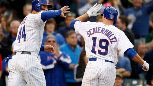 Chicago Cubs' Anthony Rizzo, left, celebrates with Nate Schierholtz after Rizzo scored on Schierholtz's sacrifice fly against the Atlanta Braves during the eighth inning of a baseball game on Saturday, Sept. 21, 2013, in Chicago. (AP Photo/Andrew A. Nelles)