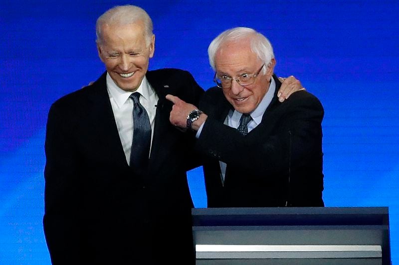 FILE - Former Vice President Joe Biden, left, embraces Sen. Bernie Sanders, I-Vt., during a Democratic presidential primary debate, Feb. 7, 2020, hosted by ABC News, Apple News, and WMUR-TV at Saint Anselm College in Manchester, N.H. (AP Photo/Elise Amendola, File)