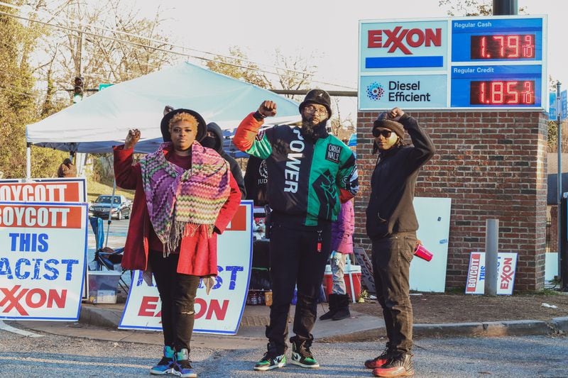 From left, protesters Meredith Minor, Brian Page and Scotty Smarts pose for a photo outside the Exxon gas station at 2345 Flat Shoals Road in DeKalb County last fall. SPECIAL PHOTO/EMERALD GREEN/PHOTOKINETIC PHOTOGRAPHY
