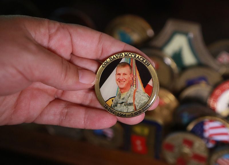 Tammy McCracken holds a challenge coin she had made to memorialize her husband, David. Curtis Compton/ccompton@ajc.com