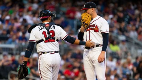 Braves catcher Alex Jackson  heads back to the plate after talking with pitcher Sean Newcomb during the second inning Saturday, April 13, 2019, at SunTrust Park in Atlanta.