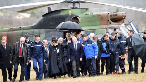 French Interior Minister Bernard Cazeneuve (center) is sheltered from the rain upon his arrival in Seyne, southeastern France. (Photo: Getty Images)