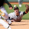 Detroit Tigers shortstop Zack Short flips the ball toward second base on an infield single hit by Oakland Athletics' Esteury Ruiz during the eighth inning of a baseball game in Oakland, Calif., Saturday, Sept. 23, 2023. (AP Photo/Jeff Chiu)