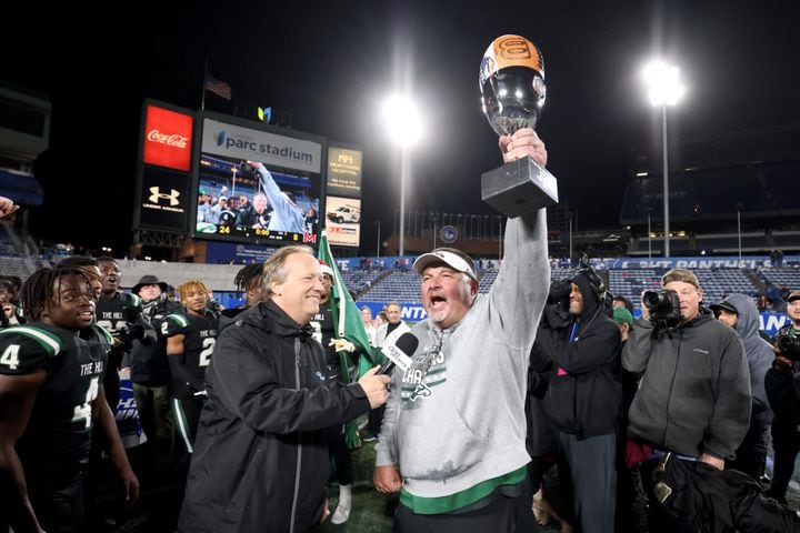 Collins Hill head coach Lenny Gregory hoist the trophy after their 24-8 win against Milton in the Class 7A state title football game at Georgia State Center Parc Stadium Saturday, December 11, 2021, Atlanta. JASON GETZ FOR THE ATLANTA JOURNAL-CONSTITUTION