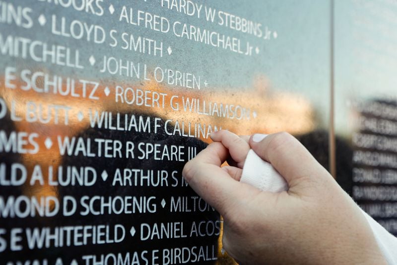 Meagan Danley helps her son, William, touch the name of his great-grandfather, William Callinan, at the Vietnam Veterans Memorial wall at the National Infantry Museum in Columbus on Friday, March 29, 2024. Callinan died in a helicopter crash in the Vietnam War. (Natrice Miller/ Natrice.miller@ajc.com)
