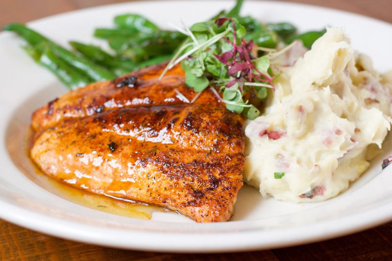 One of the entrees at Old Lady Gang is Kandi’s Glazed Blackened Salmon with red mashed potatoes and Mama Joyce’s green beans. It’s named for owner Kandi Burruss, one of the stars of “Real Housewives of Atlanta.” CONTRIBUTED BY HENRI HOLLIS