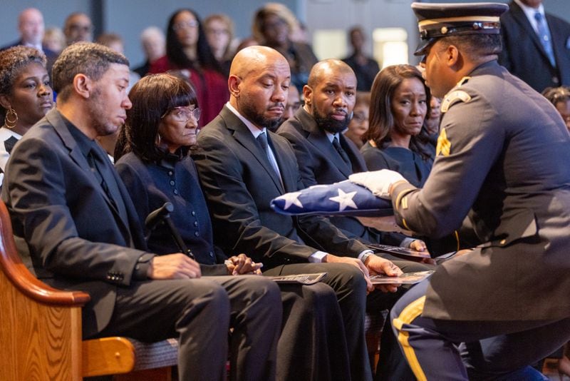 An honor guard member gives a flag to Janet Hankerson, wife of David Hankerson, former Cobb County manager, during David’s funeral at Turner Chapel AME Church in Marietta on Wednesday, February 7, 2024. (Arvin Temkar / arvin.temkar@ajc.com)