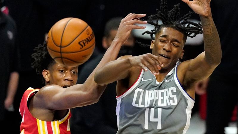 Hawks forward De'Andre Hunter and Los Angeles Clippers guard Terance Mann go after a rebound during the first half Monday, March 22, 2021, in Los Angeles. (AP)