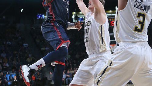 122915 ATLANTA: Duquesne guard Derrick Colter looks to pass on a double team by Georgia Tech Defenders Ben Lammers (center) and Marcus Georges-Hunt in a basketball game on Tuesday, Dec. 29, 2015, in Atlanta. Curtis Compton / ccompton@ajc.com