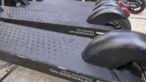 The message to not ride an e-scooter on the sidewalk is displayed on the base of a scooter parked along Peachtree Street NE in Atlanta’s Midtown, August 6, 2019. Alyssa Pointer/alyssa.pointer@ajc.com