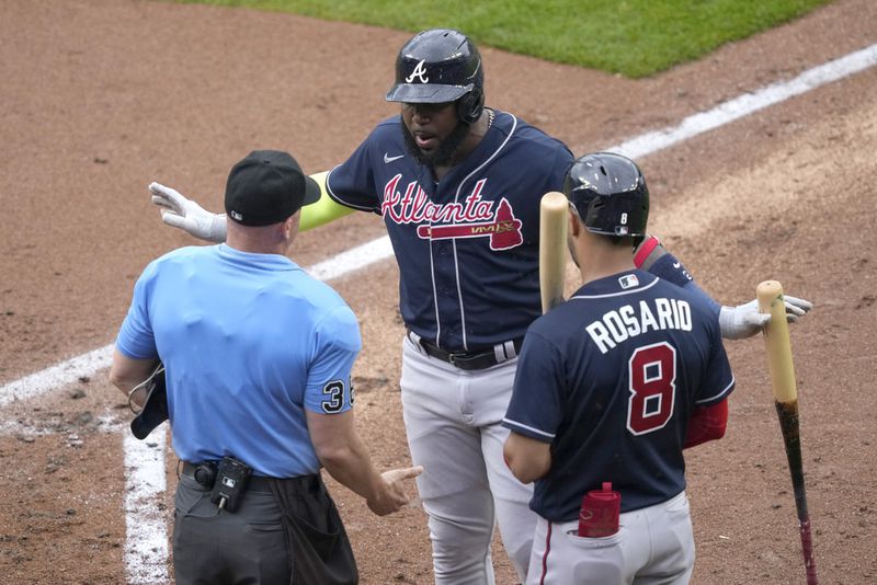 Atlanta Braves' Marcell Ozuna, center, argues with home plate umpire Ryan Blakney, left, as Braves' Eddie Rosario (8) listens after Blakney tossed Ozuna in the fourth inning of a baseball game against the Chicago Cubs, Saturday, Aug. 5, 2023, in Chicago. (AP Photo/Charles Rex Arbogast)