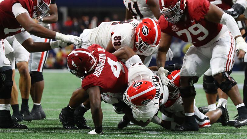 Bulldogs defensive lineman Jalen Carter (88) and fellow lineman Travon Walker (44) stop Alabama running back Brian Robinson Jr. for no gain in the second quarter of the SEC Championship game. (Curtis Compton / Curtis.Compton@ajc.com)