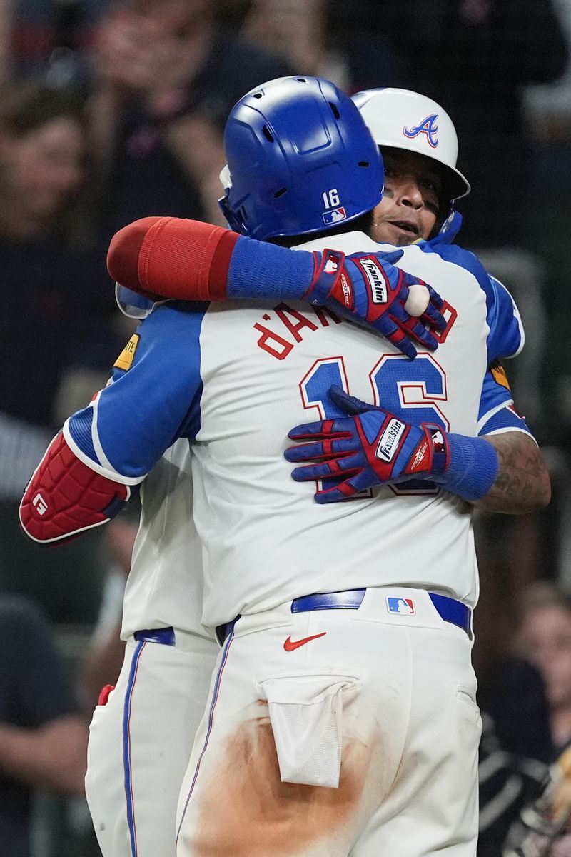 Atlanta Braves' Travis d'Arnaud (16) is embraced by Orlando Arica after hitting a two-run home run in the eighth inning of a baseball game against the Texas Rangers Saturday, April 20, 2024, in Atlanta. (AP Photo/John Bazemore)