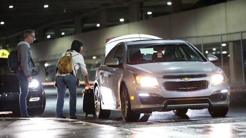 Passengers load their luggage into an Uber driver’s car at Hartsfield-Jackson Atlanta International Airport. BRANDEN CAMP/SPECIAL