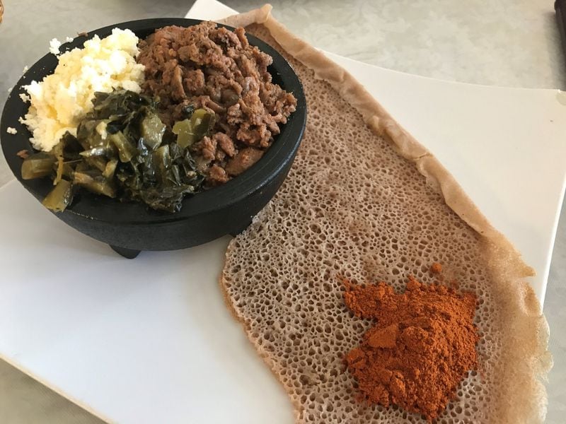 Bole Special Kitfo brings beef tartare seasoned with a chili spice blend called mitmita. The meat is served with house-made ayib (an Ethiopian cheese similar to cottage cheese) and collard greens. LIGAYA FIGUERAS / LFIGUERAS@AJC.COM