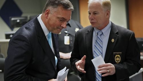 Acting Cobb District Attorney John Melvin (left) and Cobb County Police Chief Michael Register confer before announcing an indictment charging 11 alleged members of the criminal street gang known as “1831” with crimes, including racketeering, gang act violations, armed robbery, aggravated assault, battery, and narcotics and firearm charges. Most of those charged were taken into custody Friday at various locations in Cobb, Paulding, Fulton, Fayette and Baldwin Counties, including Milledgeville. BOB ANDRES / BANDRES@AJC.COM