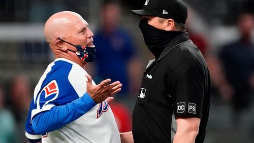 Braves manager Brian Snitker (left) argues with umpire Lance Barrett after the Philadelphia Phillies scored a run in the ninth inning Sunday, April 11, 2021, at Truist Park in Atlanta. Snitker argued the Phillies' Alec Bohm never touched the plate. The Phillies won 7-6. (John Bazemore/AP)