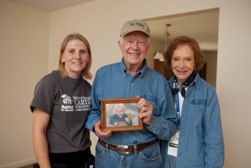 Angie Moon, President Carter and Rosalynn Carter at a 2010 Habitat Build. Carter is holding a photo of Moon's daughter, Carter Kathleen.