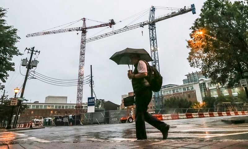 September 11, 2017 Atlanta: Rob Granberry passes the cranes on Fourth and West Peachtree streets in Midtown Atlanta on Monday, September 11, 2017 as tropical storm, Irma began to make its presence know in Atlanta on Monday, Sept. 11, 2017. 