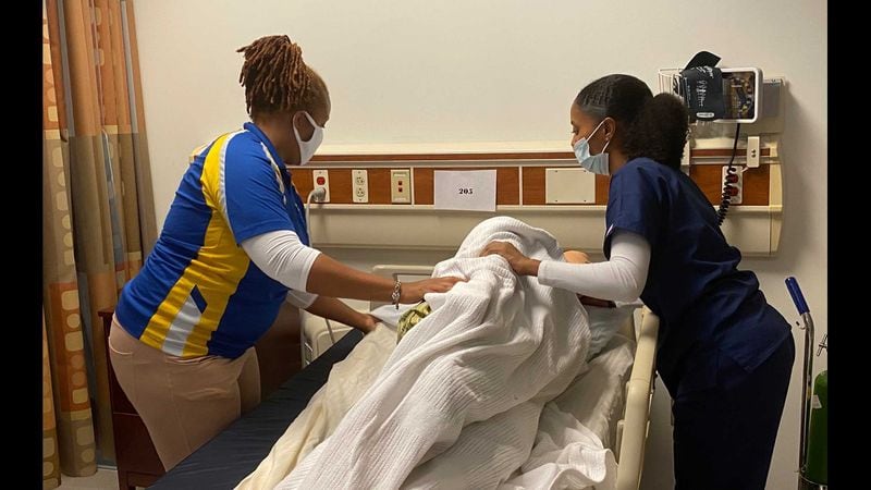 Atlanta Technical College instructor Kendra Jackson-Smith (left) works with student Taylor Moore (right) on how to properly move a patient while making up their bed during a nursing class on Aug. 13, 2020. (Eric Stirgus/Eric.Stirgus@ajc.com)