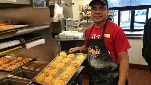 Bojangles employee Luis Santos holds a tray of biscuits. Santos is competing in the finals of the company's master biscuit-making competition. / Ligaya Figueras