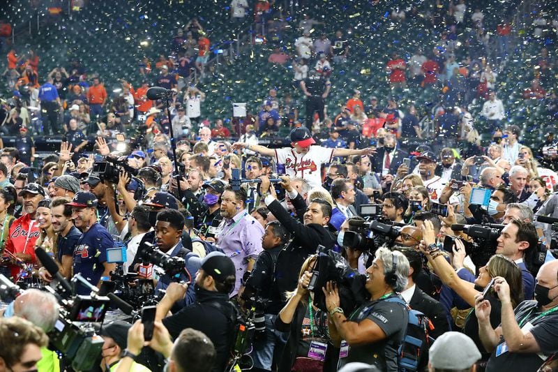 A young Atlanta Braves fan takes in the confetti flying behind a host of media covering the celebration after the Braves beat the Houston Astros in Game 6 to win the World Series on Tuesday, Nov. 2, 2021, in Houston, Texas. (Curtis Compton / Curtis.Compton@ajc.com)