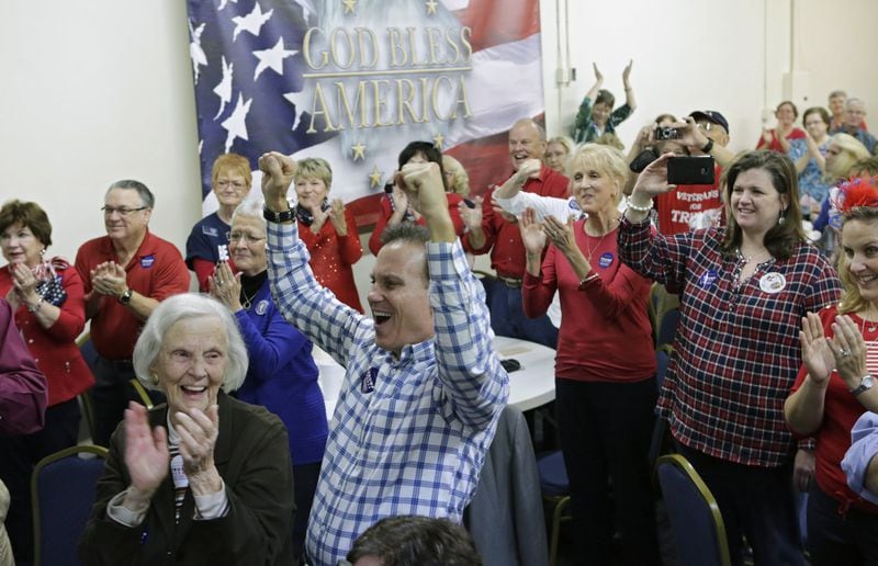 John Hightower (center) and Wanda Craven Reese (left) cheer with fellow Republicans after Donald Trump is sworn in. Cobb County Republicans watched the Inauguration of Donald Trump at a party at GOP headquarters in Marietta. BOB ANDRES /BANDRES@AJC.COM