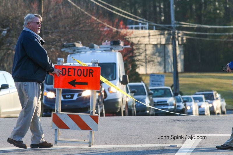 Vernon Mullins with AT&T waits for the company's drivers to come down South Old Peachtree Road, where there was a water main break. JOHN SPINK / JSPINK@AJC.COM