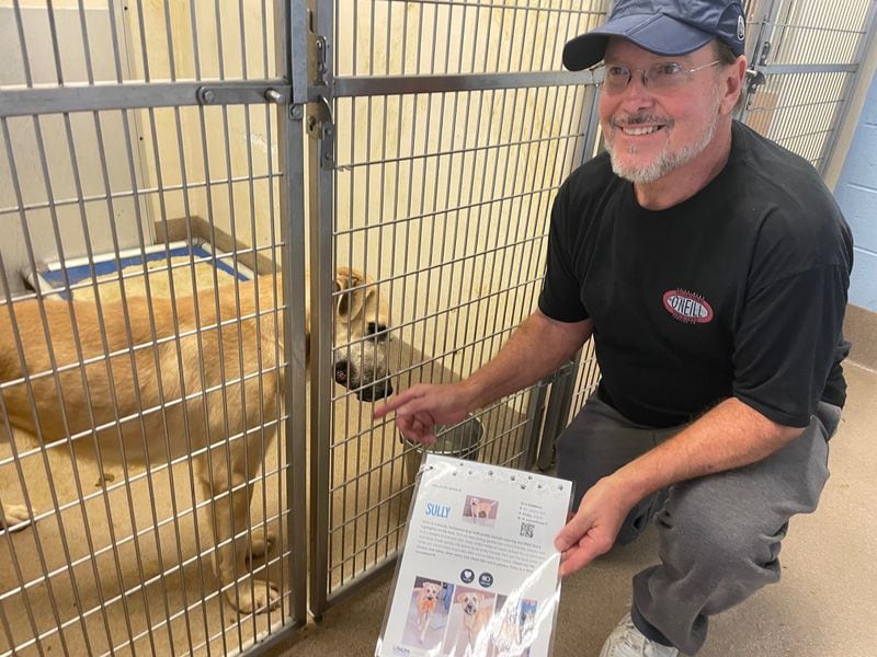 Mike Helms gets to know his soon-to-be new dog, "Sully," at the DeKalb County Animal Shelter.