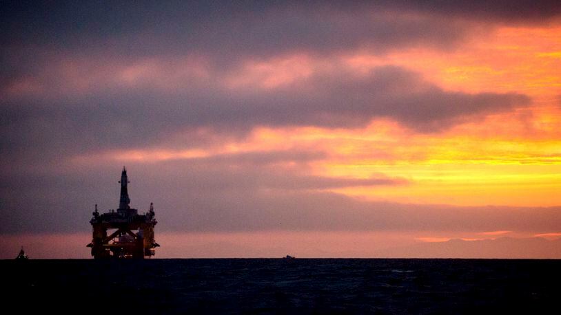 In this 2015 file photo, an oil drilling rig arrives aboard a transport ship at sunrise, following a journey across the Pacific in Port Angeles, Wash. Daniella Beccaria/seattlepi.com via AP