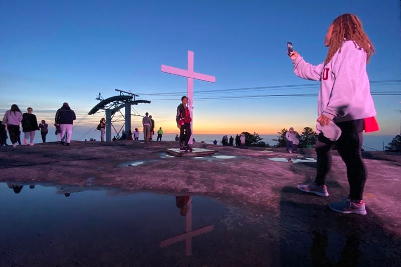 Sherice Dowling takes a photo of Ricia Taylor as she poses with the cross during the 76th annual Easter Sunrise Service on Sunday, April 17, 2022. Miguel Martinez/miguel.martinezjimenez@ajc.com