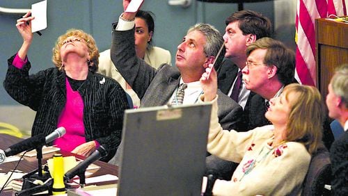 Surrounded by attorneys for the Democratic and Republican parties, the Palm Beach County, Florida, election canvassing board examines questionable ballots in the county Emergency Operations Center, where the hand count of all Palm Beach County ballots is taking place in this photo from November 24, 2000. (Lannis Waters/Palm Beach Post/TNS) 