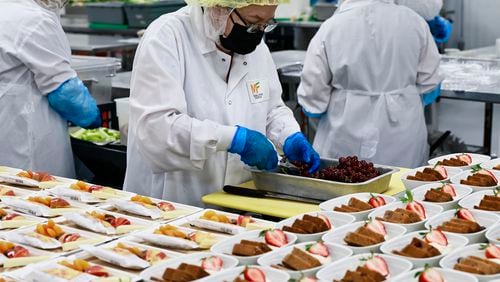 Mainline Aviation employees plate meals for in-flight catering on Friday, August 5, 2022. (Natrice Miller/natrice.miller@ajc.com)