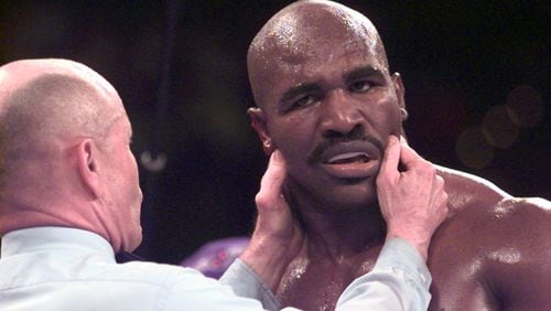 Referee Mills Lane inspects the damage on Evander Holyfield following the first bite inflicted by Mike Tyson during their rematch in 1997. Yes, the first bite. There'd be another, and Tyson would be disqualified in one of the weirdest fights ever. (AJC Staff Photo/Joey Ivansco)