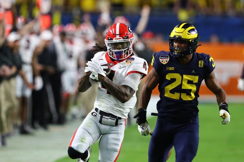 Georgia Bulldogs running back James Cook (4) completes a 53-yard pass in the second quarter of the 2021 College Football Playoff semifinal between the Georgia Bulldogs and the Michigan Wolverines at the Orange Bowl at Hard Rock Stadium in Miami Gardens. Curtis Compton / Curtis.Compton@ajc.com 